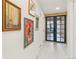 Hallway with wood floors and glass-paneled doors leading to another room, enhanced by unique artwork on the walls at 1927 Sunset Cir, Evergreen, CO 80439