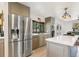 Modern kitchen featuring stainless steel refrigerator, gas range, ample cabinets and a bright window at 1927 Sunset Cir, Evergreen, CO 80439