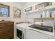Bright laundry room with modern washer and dryer, upper cabinets, and a window at 1927 Sunset Cir, Evergreen, CO 80439