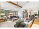 Bright, open-concept living space with comfortable gray sofas, views and wood beams at 1927 Sunset Cir, Evergreen, CO 80439