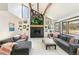 Bright living room with high ceilings, wood beams, fireplace, and gray couches at 1927 Sunset Cir, Evergreen, CO 80439
