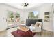 Sunlit sitting room featuring neutral armchairs, a dark console table, and glass doors to backyard at 1927 Sunset Cir, Evergreen, CO 80439