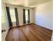 Sunlit bedroom features wood floors and large windows with neutral gray drapes at 10561 W Dartmouth Ave, Lakewood, CO 80227