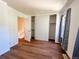Sunlit bedroom features wood floors and closets with neutral gray drapes at 10561 W Dartmouth Ave, Lakewood, CO 80227