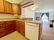 Efficient kitchen with wood cabinets, stainless steel sink, and an adjacent living area at 10561 W Dartmouth Ave, Lakewood, CO 80227
