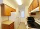 Efficient kitchen with wood cabinets, white appliances, and ample counter space at 10561 W Dartmouth Ave, Lakewood, CO 80227