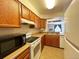 Well-lit kitchen features wood cabinets, black microwave, and white appliances at 10561 W Dartmouth Ave, Lakewood, CO 80227