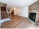Living room with brick fireplace and hardwood floors near an open staircase at 10561 W Dartmouth Ave, Lakewood, CO 80227