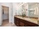 Bathroom with dual sinks, granite countertops, and a glass-enclosed shower at 11791 Barrentine Loop, Parker, CO 80138