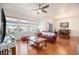 Bright living room with a ceiling fan, hardwood floors, and a view of the adjacent dining area at 11791 Barrentine Loop, Parker, CO 80138
