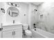 Bathroom with a white vanity, black fixtures, a tub with marble-style tile surround, and a round mirror at 6519 Pinewood Dr, Parker, CO 80134