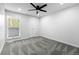 Bright bedroom featuring plush gray carpeting, ceiling fan, and a window at 6519 Pinewood Dr, Parker, CO 80134