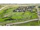 Scenic aerial view of the golf course with tree-lined fairways and distant homes at 6519 Pinewood Dr, Parker, CO 80134