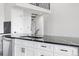 Modern kitchen island with stainless steel faucet, quartz countertops and white cabinets with black hardware at 6519 Pinewood Dr, Parker, CO 80134