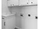 Well-lit laundry room with white cabinets, quartz countertop, and utility connections for appliances at 6519 Pinewood Dr, Parker, CO 80134