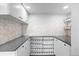 Pantry space with white cabinets, quartz countertops, and built-in wine rack shelves for organized storage at 6519 Pinewood Dr, Parker, CO 80134