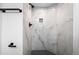 Modern shower featuring marble-style tiles, black fixtures, and a convenient niche for toiletries at 6519 Pinewood Dr, Parker, CO 80134