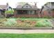 Charming brick bungalow featuring a beautifully landscaped front yard and cozy front porch at 832 S Gilpin St, Denver, CO 80209