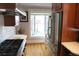 Well-lit kitchen featuring stainless steel appliances, wood floors, and bright window with a view at 832 S Gilpin St, Denver, CO 80209