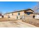 Charming home exterior showcasing a well-maintained yard, a metal fence, and a driveway leading to the property at 119 Yakima St, Lochbuie, CO 80603