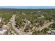 Aerial view of a single house on a lot surrounded by tall trees and a windy road at 17575 Minglewood Trl, Monument, CO 80132