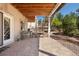Covered patio with paver stones, stairs to backyard, and bench at 17575 Minglewood Trl, Monument, CO 80132
