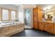 Elegant bathroom featuring a luxurious soaking tub, glass enclosed shower, and vanity with dual sinks at 17575 Minglewood Trl, Monument, CO 80132