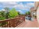 Outdoor deck with wood railings offering serene views of lush greenery and distant landscapes at 17575 Minglewood Trl, Monument, CO 80132