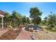 Relaxing outdoor fire pit area with seating and a hammock in the trees at 17575 Minglewood Trl, Monument, CO 80132