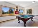 Bright game room with large windows and a classic billiard table for entertainment at 17575 Minglewood Trl, Monument, CO 80132