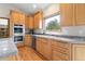 Well-lit kitchen with wood cabinetry, stainless steel oven and dishwasher, and a corner sink at 17575 Minglewood Trl, Monument, CO 80132