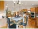 Open-concept kitchen with wood cabinets, stainless appliances and a glass table at 17575 Minglewood Trl, Monument, CO 80132
