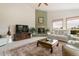 Open living room with a fireplace, a large rug, white sofas and large windows offering scenic views at 17575 Minglewood Trl, Monument, CO 80132