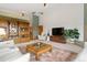 Spacious living area featuring a display case, a large patterned rug, and natural light at 17575 Minglewood Trl, Monument, CO 80132