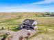 Aerial view featuring a two-story home with attached garages, circular driveway, and lush surroundings at 3654 Paintbrush Ln, Parker, CO 80138