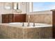 Close up of bright bathroom featuring a soaking tub with tile surround and bronze faucet at 3654 Paintbrush Ln, Parker, CO 80138