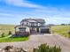 Charming two-story home features a three-car garage, complemented by a lush green lawn and blue skies at 3654 Paintbrush Ln, Parker, CO 80138