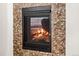 Close-up of stone fireplace with black frame and glass door at 3654 Paintbrush Ln, Parker, CO 80138