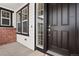 Close-up of front entry with modern door hardware, sidelight windows, and brick detailing at 3654 Paintbrush Ln, Parker, CO 80138