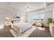 Bright main bedroom featuring tray ceilings, chandelier, sitting area, and neutral color palette at 3654 Paintbrush Ln, Parker, CO 80138