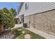 An outdoor patio with a grill and brick-and-vinyl siding and stepping stones to a grassy area at 4912 Altura St, Denver, CO 80239