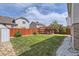 Large grassy backyard with a pergola-covered deck, a wooden fence, and lush landscaping at 4912 Altura St, Denver, CO 80239