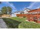 Fenced backyard featuring green lawn, storage shed, and wooden pergola with deck at 4912 Altura St, Denver, CO 80239