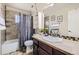 This full bathroom has decorative tiling in the shower and around the mirror and sink at 4912 Altura St, Denver, CO 80239
