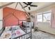 Bright bedroom features modern ceiling fan, a bed, a crib, and a large window for natural light at 4912 Altura St, Denver, CO 80239