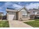 Charming brick home with attached garage, complemented by a lush green lawn and clear blue skies at 4912 Altura St, Denver, CO 80239
