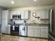 Beautiful kitchen boasts stainless steel appliances, light cabinets, tile backsplash, countertops, and tiled flooring at 4912 Altura St, Denver, CO 80239