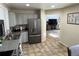 The kitchen opens to the living room, complete with stainless appliances, light cabinets, and tiled flooring at 4912 Altura St, Denver, CO 80239