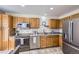 Well-equipped kitchen showcasing stainless steel appliances, wood cabinets, and functional layout at 4912 Altura St, Denver, CO 80239