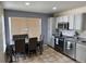 Well-lit kitchen features an adjacent dining area, stainless steel appliances, tile backsplash, and tiled flooring at 4912 Altura St, Denver, CO 80239